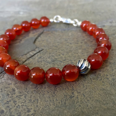 Carnelian 8mm beads bracelet with sterling silver lobster clasp. Has one accent sterling silver wave bead.