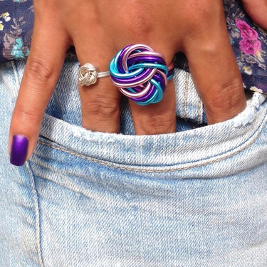 Purple, pink, and turquoise anodized aluminum wire wrap ring.
