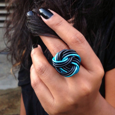 Black and neon blue color anodized aluminum wire wrap ring. 

