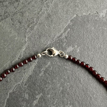 4mm BEAD NECKLACE WITH GARNET close up view of sterling silver clasp