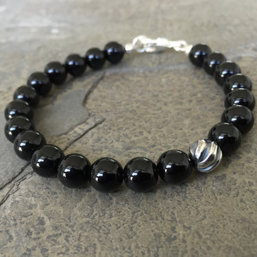 bottom view of  Gloss black onyx bead with one accent sterling silver wave bead bracelet 