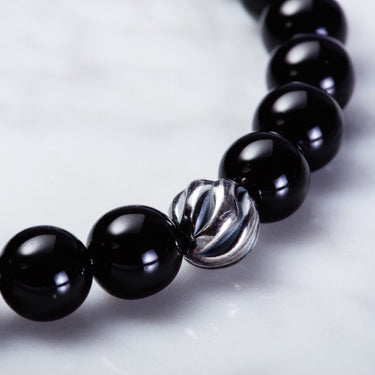 close up of Gloss black onyx bead with one accent sterling silver wave bead bracelet for him