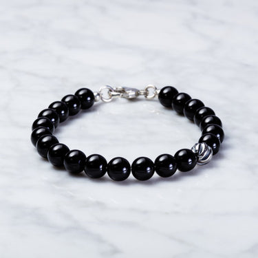 bottom view of handmade Gloss black onyx bead with one accent sterling silver wave bead bracelet 