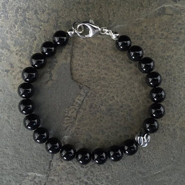 Gloss black onyx 8mm beads with one accent sterling silver wave bead bracelet 