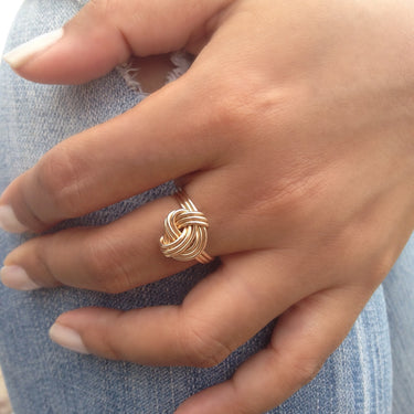Handcrafted high gloss and dainty ring is formed with three bands that are hand twisted into a tightly wrapped knot. Looks great worn alone or even better with other rings. The ring can also be worn as a mid-ring. It measures 13 x 12mm and is available in 14K yellow gold-filled, 14K rose gold-filled & sterling silver.