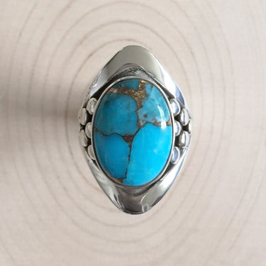top view of turquoise stone on the mens ring with sterling silver details on the side