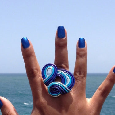 Dark blue, turquoise, and light blue color anodized aluminum wire wrap ring. 
