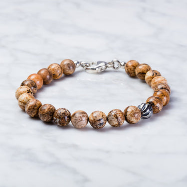 A close-up of handcrafted Picture jasper 8mm bead bracelet with one accent sterling silver wave bead. With Sterling silver components and a lobster clasp.