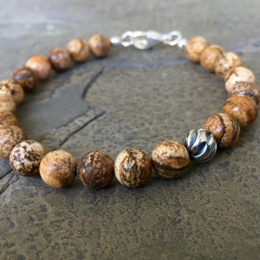 bottom view of Picture jasper 8mm bead bracelet with one accent sterling silver wave bead. With Sterling silver components and a lobster clasp.