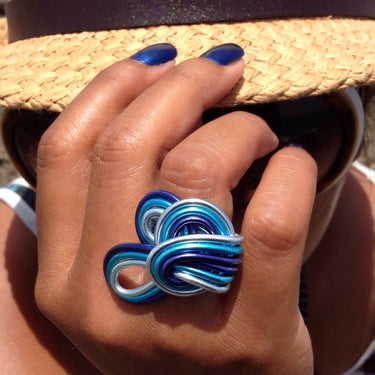 Dark blue, turquoise, and light blue color anodized aluminum wire wrap ring. 
