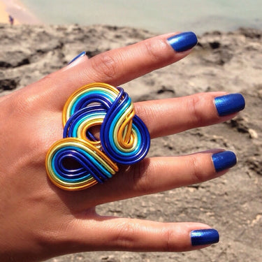 Dark blue, light green, turquoise, and orange color anodized aluminum wire wrap ring. 
