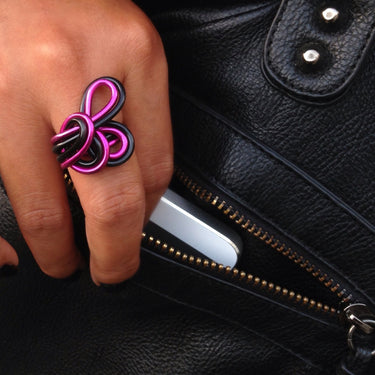 Black and pink color anodized aluminum wire wrap ring. 
